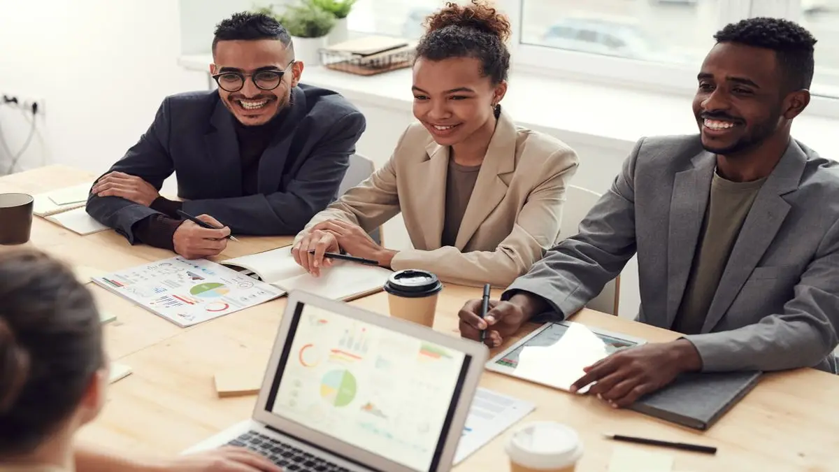 Profissionais de marketing digital analisando relatórios impressos e dashboard do Google Ads para tomada de decisão e maximização de lucro.